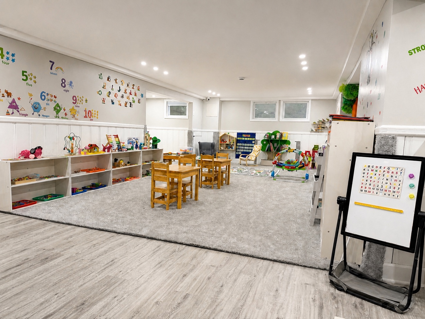 A bright, wide view of the actual Bluebird Learning Nest activity room with child-sized tables, organized materials, and open space for play